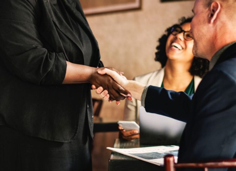 Immagine che mostra una donna sorridente proprietaria di un'azienda con una buona reputazione aziendale.