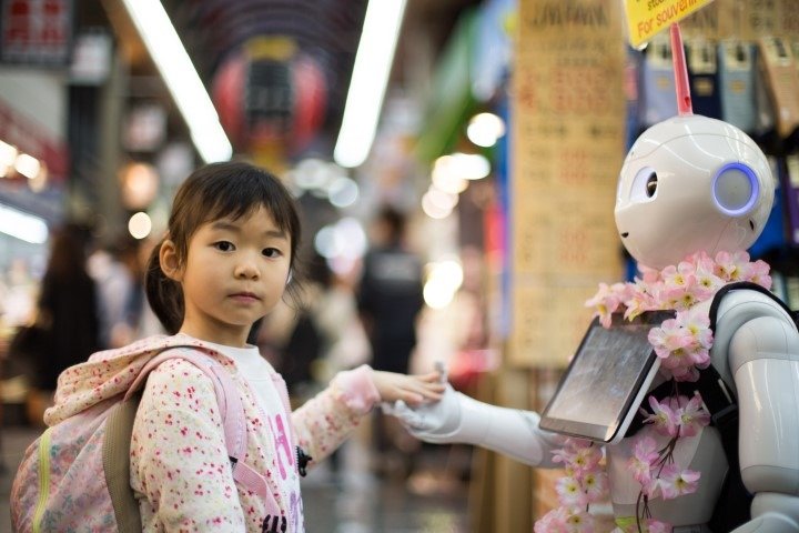 child holding the hand of a robot